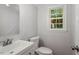 Simple bathroom featuring a white vanity, toilet, fresh paint, and natural lighting at 3129 Merrianne Dr, Raleigh, NC 27607