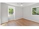 Bedroom with wood-look floors and natural light from two windows at 3129 Merrianne Dr, Raleigh, NC 27607