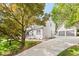 Beautiful exterior view showcasing the home, detached two-car garage, long driveway, and mature trees at 3129 Merrianne Dr, Raleigh, NC 27607
