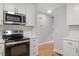 Close-up of a kitchen with white cabinets, subway tile backsplash, and stainless steel appliances at 3129 Merrianne Dr, Raleigh, NC 27607
