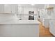 Stunning all-white kitchen with stainless steel appliances, tile backsplash, and ample countertop space at 3129 Merrianne Dr, Raleigh, NC 27607