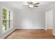 Bright living room featuring hardwood floors, large windows, and modern ceiling fan at 3129 Merrianne Dr, Raleigh, NC 27607
