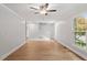 Open-concept living room with wood floors, staircase, and large windows for natural light at 3129 Merrianne Dr, Raleigh, NC 27607