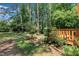 Inviting backyard with a lush green lawn, mature trees, and a wooden deck at 320 Bainbridge Cir, Garner, NC 27529