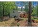 View of the home's exterior featuring a deck, a grill, and a partially wooded lot at 320 Bainbridge Cir, Garner, NC 27529
