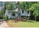 Light blue split-level home with white shutters surrounded by trees and grass at 320 Bainbridge Cir, Garner, NC 27529