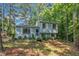 Beautiful light blue split-level home with white shutters surrounded by lush greenery and mature trees at 320 Bainbridge Cir, Garner, NC 27529