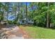 Split-level home with light blue siding surrounded by mature trees and green grass at 320 Bainbridge Cir, Garner, NC 27529