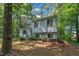Split-level home with light blue siding and white shutters nestled in a lush, green, wooded lot at 320 Bainbridge Cir, Garner, NC 27529