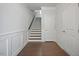 Clean foyer with wood floors, white wainscoting, staircase, and white doors creating a neat and welcoming space at 341 View Dr, Morrisville, NC 27560
