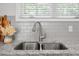 Granite countertop with stainless steel sink and tile backsplash near bright window at 341 View Dr, Morrisville, NC 27560