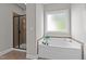 Bright bathroom with a soaking tub, tile surround, and a separate glass-enclosed shower at 3525 Daisy Ln, Wake Forest, NC 27587