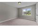 A bedroom with neutral walls, plush carpeting, and a window provides natural light and a calm ambiance at 3525 Daisy Ln, Wake Forest, NC 27587