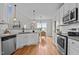 Modern kitchen featuring white cabinets, stainless steel appliances, and hardwood floors at 3525 Daisy Ln, Wake Forest, NC 27587
