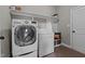 Laundry room with a front-load washer, dryer, storage, built-in shelves, and tiled flooring at 3525 Daisy Ln, Wake Forest, NC 27587