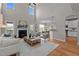 Sunlit living room featuring a fireplace, wood floors, and a view into the dining and kitchen area at 3525 Daisy Ln, Wake Forest, NC 27587