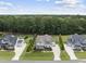 Aerial view of a beautiful home with well-maintained landscaping, flanked by neighboring houses and a lush green forest at 3829 Sleepy Brook Ln, Apex, NC 27539