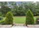 Lush backyard featuring green lawn, mature trees, and manicured shrubbery at 3829 Sleepy Brook Ln, Apex, NC 27539