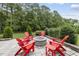 Inviting backyard with stone patio and fire pit surrounded by bright red Adirondack chairs at 3829 Sleepy Brook Ln, Apex, NC 27539