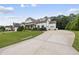 Inviting exterior of a white home with lush green lawn and a long driveway leading to the garage at 3829 Sleepy Brook Ln, Apex, NC 27539