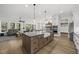 Bright, open kitchen featuring a large island with seating, farmhouse sink, modern appliances, and wood flooring at 3829 Sleepy Brook Ln, Apex, NC 27539