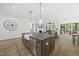 Bright, open kitchen featuring a large island, farmhouse sink, modern appliances and an open flow to the living and dining areas at 3829 Sleepy Brook Ln, Apex, NC 27539