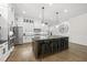 Spacious kitchen with an oversized island, seating, stainless steel appliances, and stylish pendant lighting at 3829 Sleepy Brook Ln, Apex, NC 27539