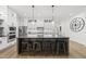 Spacious kitchen featuring a large center island with seating, stainless steel appliances and hardwood flooring at 3829 Sleepy Brook Ln, Apex, NC 27539