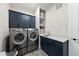 Well-equipped laundry room with modern appliances, navy cabinetry, and ample storage space for organization at 3829 Sleepy Brook Ln, Apex, NC 27539