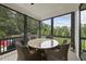 Relaxing screened porch featuring round table, chairs, and a picturesque view of surrounding trees at 3829 Sleepy Brook Ln, Apex, NC 27539