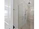 Modern tiled shower featuring glass doors, dual shower heads, a built-in bench, and hexagon tile floors at 3829 Sleepy Brook Ln, Apex, NC 27539