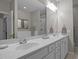 Bathroom featuring double sinks, marble counters, and a large mirror with vanity lighting at 3902 Stags Leap Cir, Raleigh, NC 27612