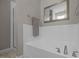 Bright white tub with chrome fixtures, tiled backsplash, and separate tiled shower area at 3902 Stags Leap Cir, Raleigh, NC 27612