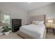 Cozy bedroom with a tufted headboard, black dresser, and a leafy houseplant at 3902 Stags Leap Cir, Raleigh, NC 27612
