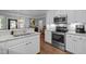 Modern kitchen featuring granite countertops, white cabinets, and stainless steel appliances at 3902 Stags Leap Cir, Raleigh, NC 27612