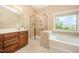 Bathroom with a glass shower, tub, wood cabinet vanity, and a bright window at 404 Panorama Park Pl, Cary, NC 27519