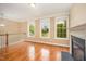 Bright living room featuring a cozy fireplace, hardwood floors, and neutral wall paint at 404 Panorama Park Pl, Cary, NC 27519
