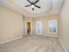 Spacious main bedroom with tray ceiling, ceiling fan, and carpeted floors at 404 Panorama Park Pl, Cary, NC 27519