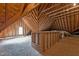Partially finished attic featuring exposed rafters, insulation, and natural light at 4315 Sugar Pine Ln, Durham, NC 27705