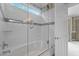 Modern bathroom with a glass-enclosed shower-tub combination with white tiles and marble accents at 4315 Sugar Pine Ln, Durham, NC 27705