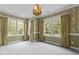 Spacious bedroom boasts decorative wallpaper, crown molding, and three large windows at 4315 Sugar Pine Ln, Durham, NC 27705