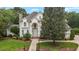 Stately white home with manicured lawn and inviting walkway leads to the front door at 4315 Sugar Pine Ln, Durham, NC 27705