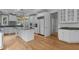 Spacious white kitchen with a center island, wood floors, granite countertops, and stainless appliances at 4315 Sugar Pine Ln, Durham, NC 27705