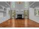 Spacious living room featuring hardwood floors, a fireplace, and large windows at 4315 Sugar Pine Ln, Durham, NC 27705