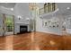Bright living room boasting hardwood floors, a fireplace, large windows, and a stunning chandelier at 4315 Sugar Pine Ln, Durham, NC 27705