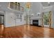 Elegant living room with hardwood floors, built-in shelves, a fireplace, large windows, and French doors at 4315 Sugar Pine Ln, Durham, NC 27705