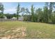 A spacious backyard with a trampoline and partially enclosed by a black metal fence at 433 Village Bend Dr, Fuquay Varina, NC 27526