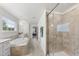 Bright bathroom featuring a soaking tub, glass shower, tile flooring and neutral color palette at 433 Village Bend Dr, Fuquay Varina, NC 27526