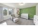 Serene Bedroom featuring a crib, accent wall, comfortable chair, and soft neutral tones at 433 Village Bend Dr, Fuquay Varina, NC 27526