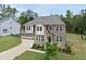 A beautiful two-story home with a stone and siding facade, with a spacious lawn and driveway at 433 Village Bend Dr, Fuquay Varina, NC 27526